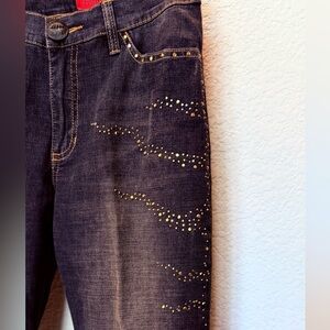 Christina denim faded black denim jeans with gold accents along the front sides.